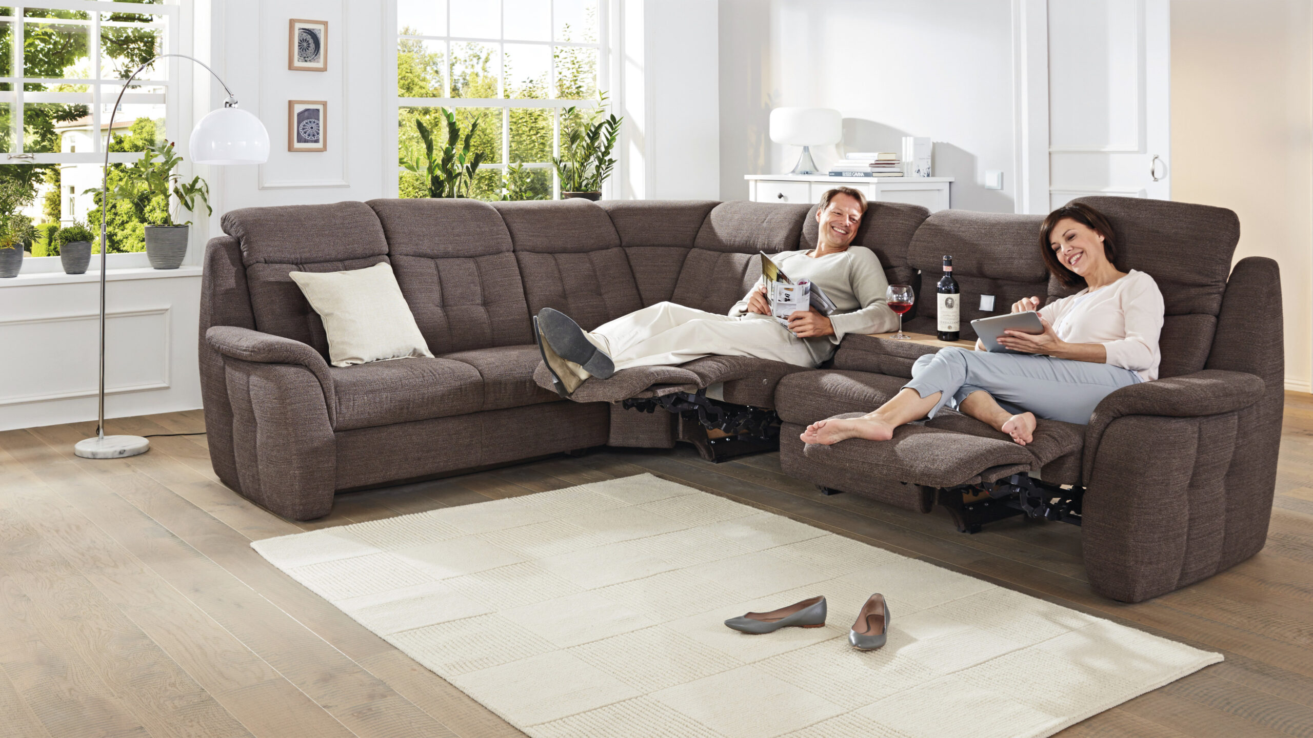 Komfortable Wohnzimmer-Szenerie mit Sofa und entspannenden Personen.